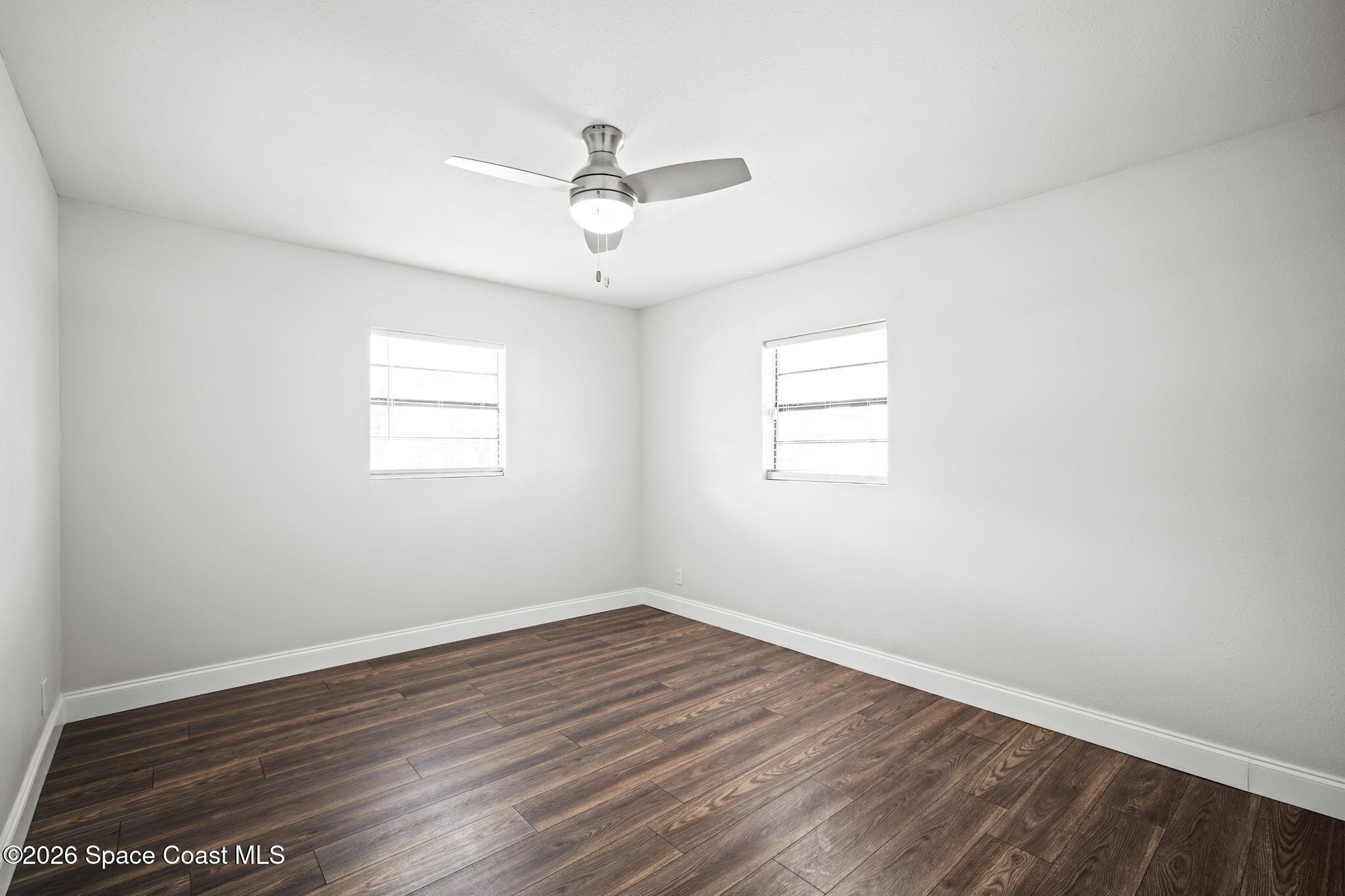 4665 Tuscarora Road Titusville, FL 32780 - Photo 19 of 34 wooden floor in an empty room with a window
