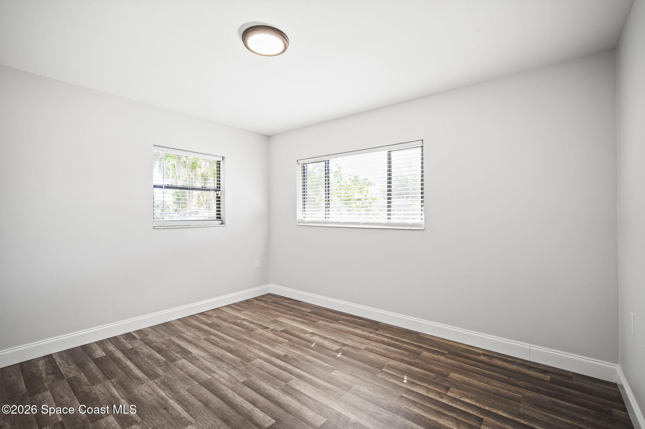 4665 Tuscarora Road Titusville, FL 32780 - Photo 22 of 34 an empty room with wooden floor and windows