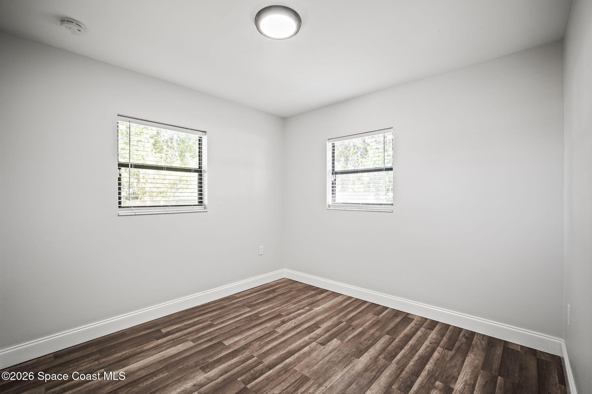 4665 Tuscarora Road Titusville, FL 32780 - Photo 24 of 34 an empty room with wooden floor and windows
