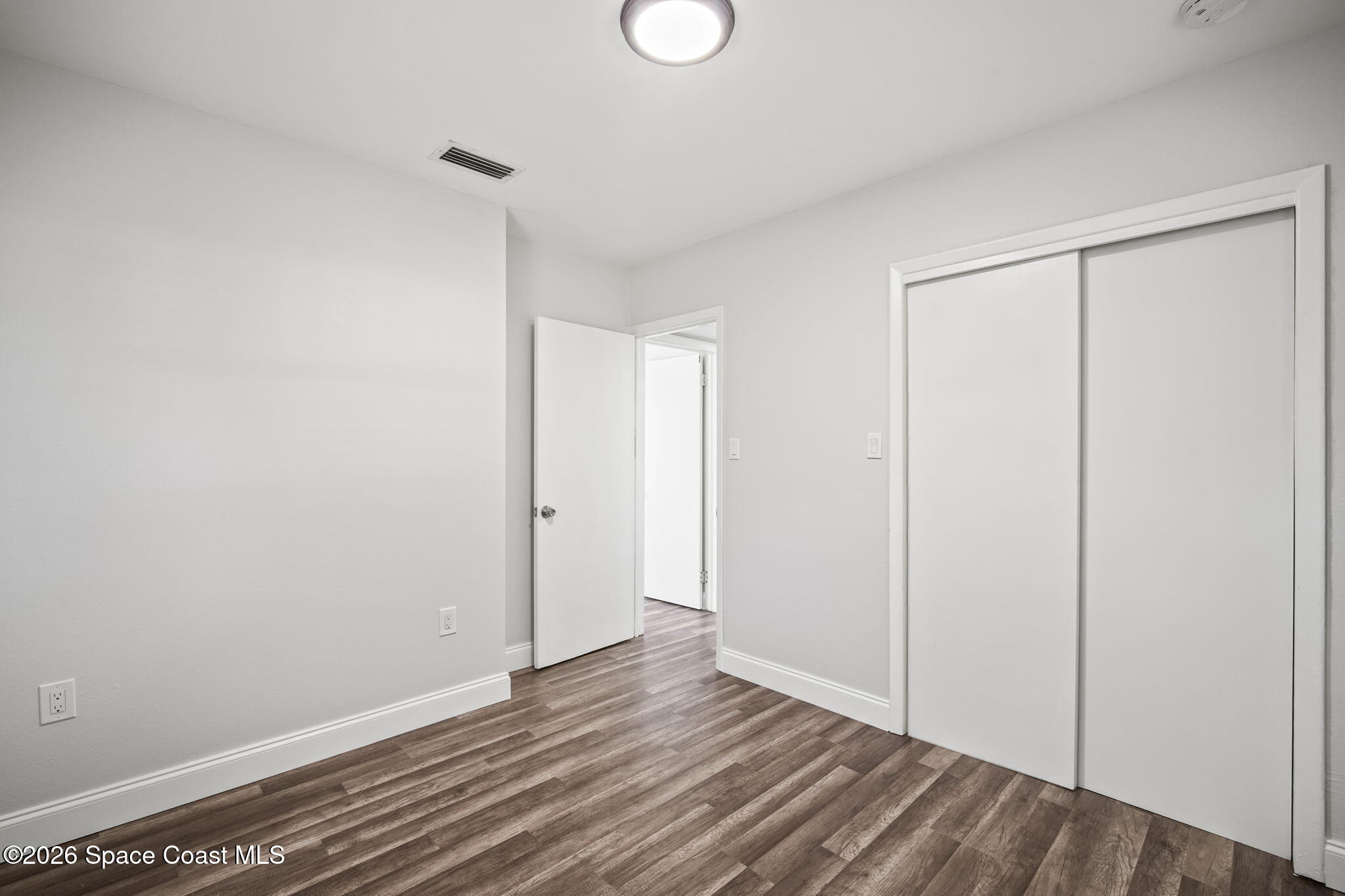 4665 Tuscarora Road Titusville, FL 32780 - Photo 25 of 34 a view of an empty room with wooden floor and a window