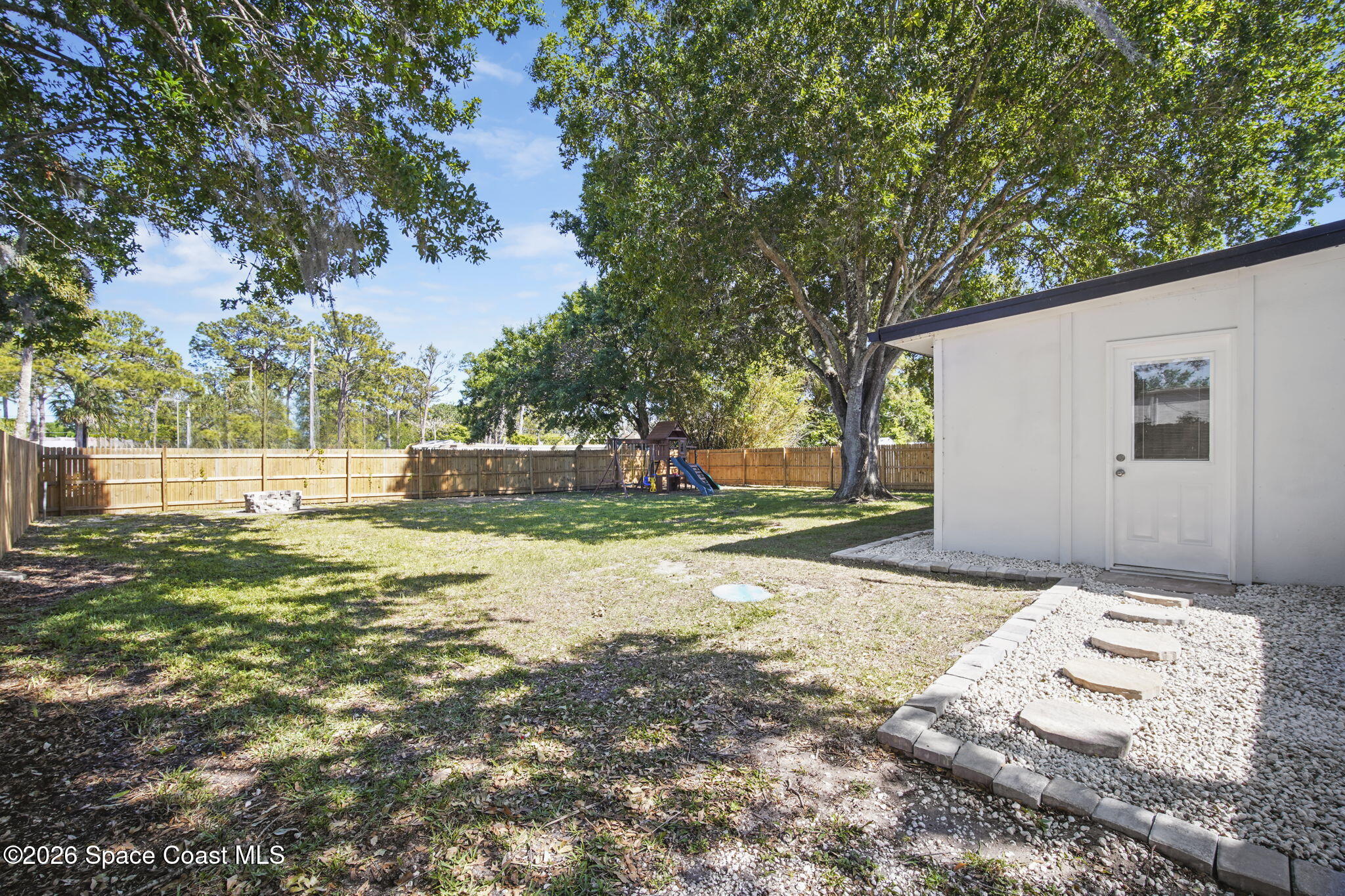 4665 Tuscarora Road Titusville, FL 32780 - Photo 31 of 34 a view of a backyard with large trees