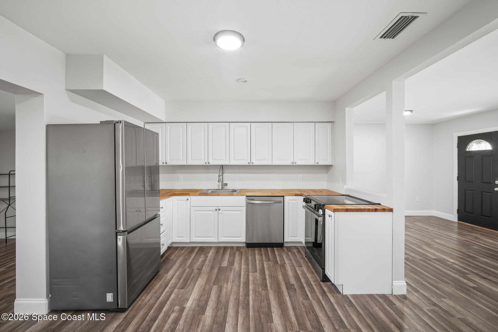 4665 Tuscarora Road Titusville, FL 32780 - Photo 9 of 34 a kitchen with a refrigerator a sink and wooden floor