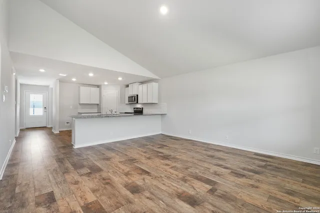 a view of kitchen with kitchen island white cabinets and refrigerator