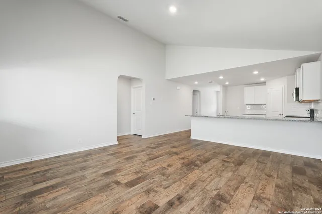 a view of an empty room with a kitchen