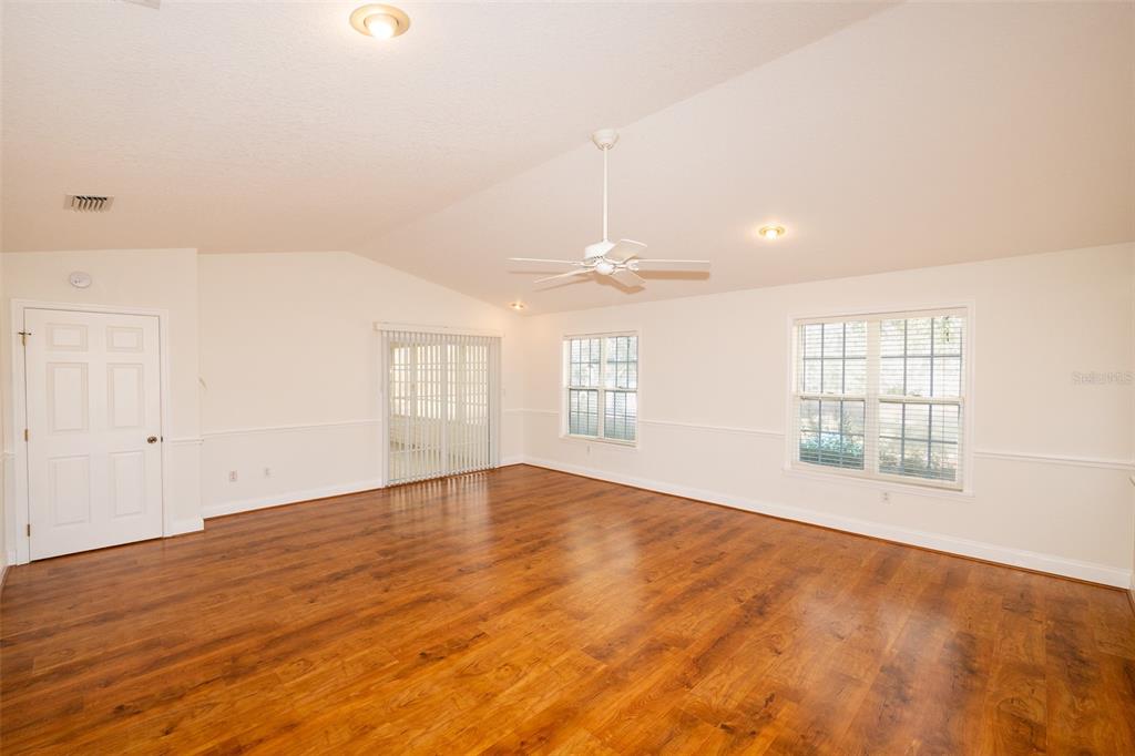 8077 Lake Hatchineha Road Haines City, FL 33844 - Photo 12 of 45 an empty room with wooden floor and windows