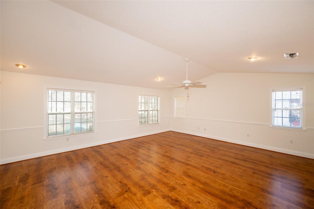 8077 Lake Hatchineha Road Haines City, FL 33844 - Photo 16 of 45 an empty room with wooden floor and windows