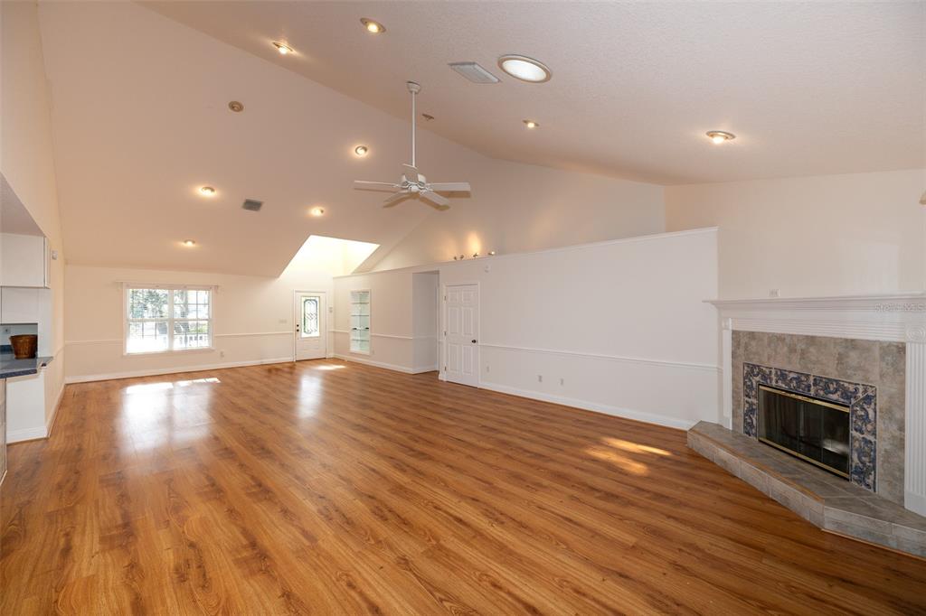8077 Lake Hatchineha Road Haines City, FL 33844 - Photo 5 of 45 an empty room with wooden floor fireplace and windows