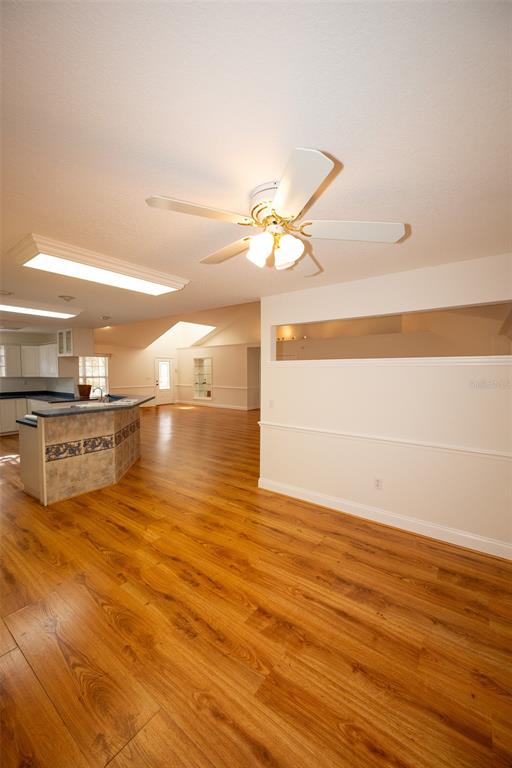 8077 Lake Hatchineha Road Haines City, FL 33844 - Photo 7 of 45 a view of kitchen and empty room with wooden floor
