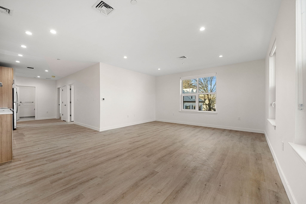 1151 Walnut Street, Unit 301 Newton, MA 02461 - Photo 7 of 14 an empty room with wooden floor and windows