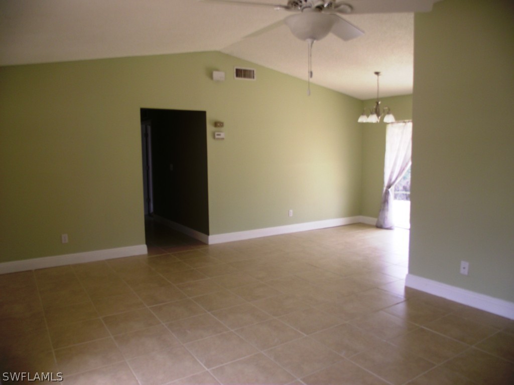 1085 Ridgeway Drive North Fort Myers, FL 33903 - Photo 13 of 25 an empty room with a chandelier fan and a window