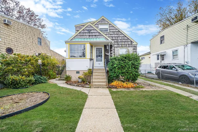 a front view of a house with a yard and potted plants