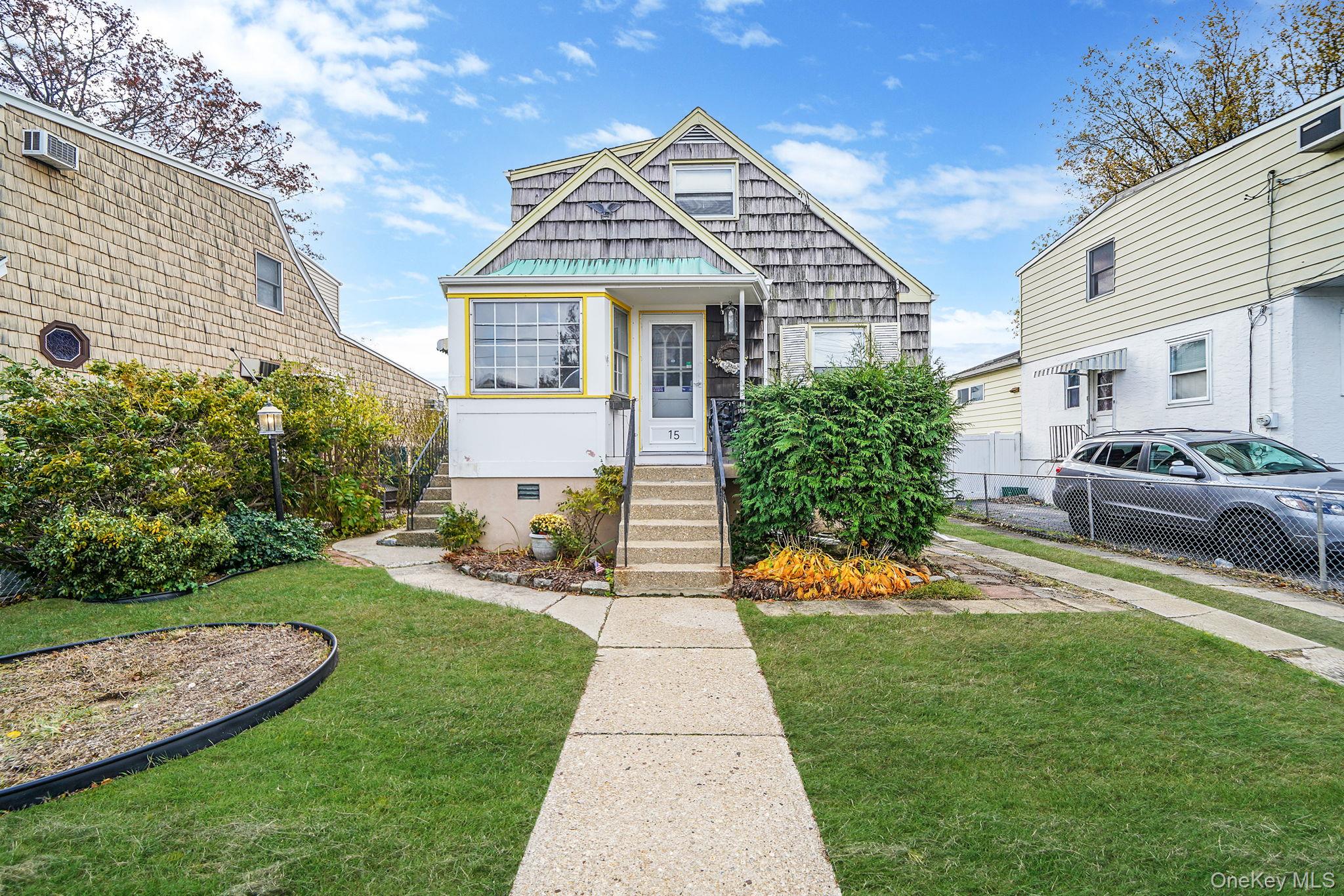 a front view of a house with a yard and potted plants