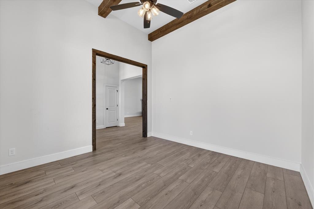 517 Longhorn Lane Springtown, TX 76082 - Photo 6 of 39 Empty room with a ceiling fan, wood finished floors, and vaulted ceiling