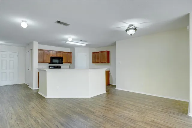 a view of kitchen with microwave and wooden floor