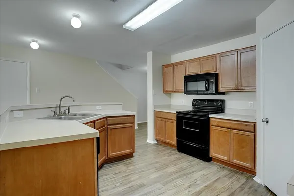 a kitchen with stainless steel appliances granite countertop a sink stove microwave and refrigerator