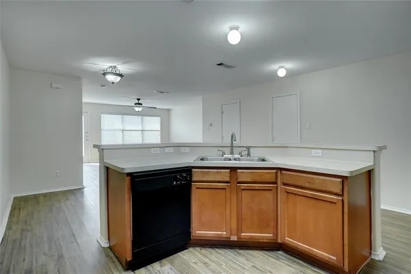 a kitchen with a sink cabinets and wooden floor