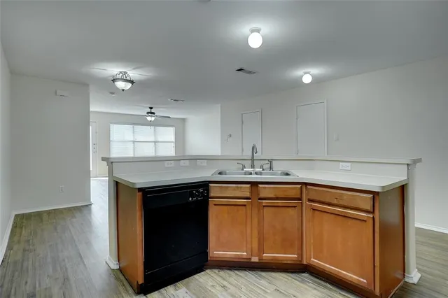 a kitchen with a sink cabinets and wooden floor