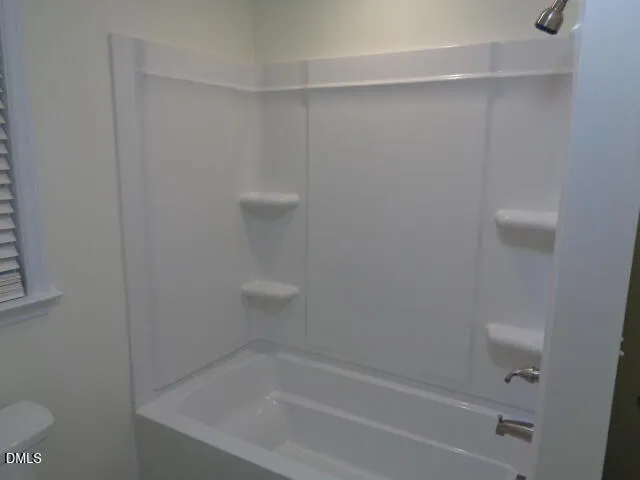 an empty room with a mirror and a fan