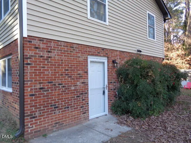 a view of a brick house with plants