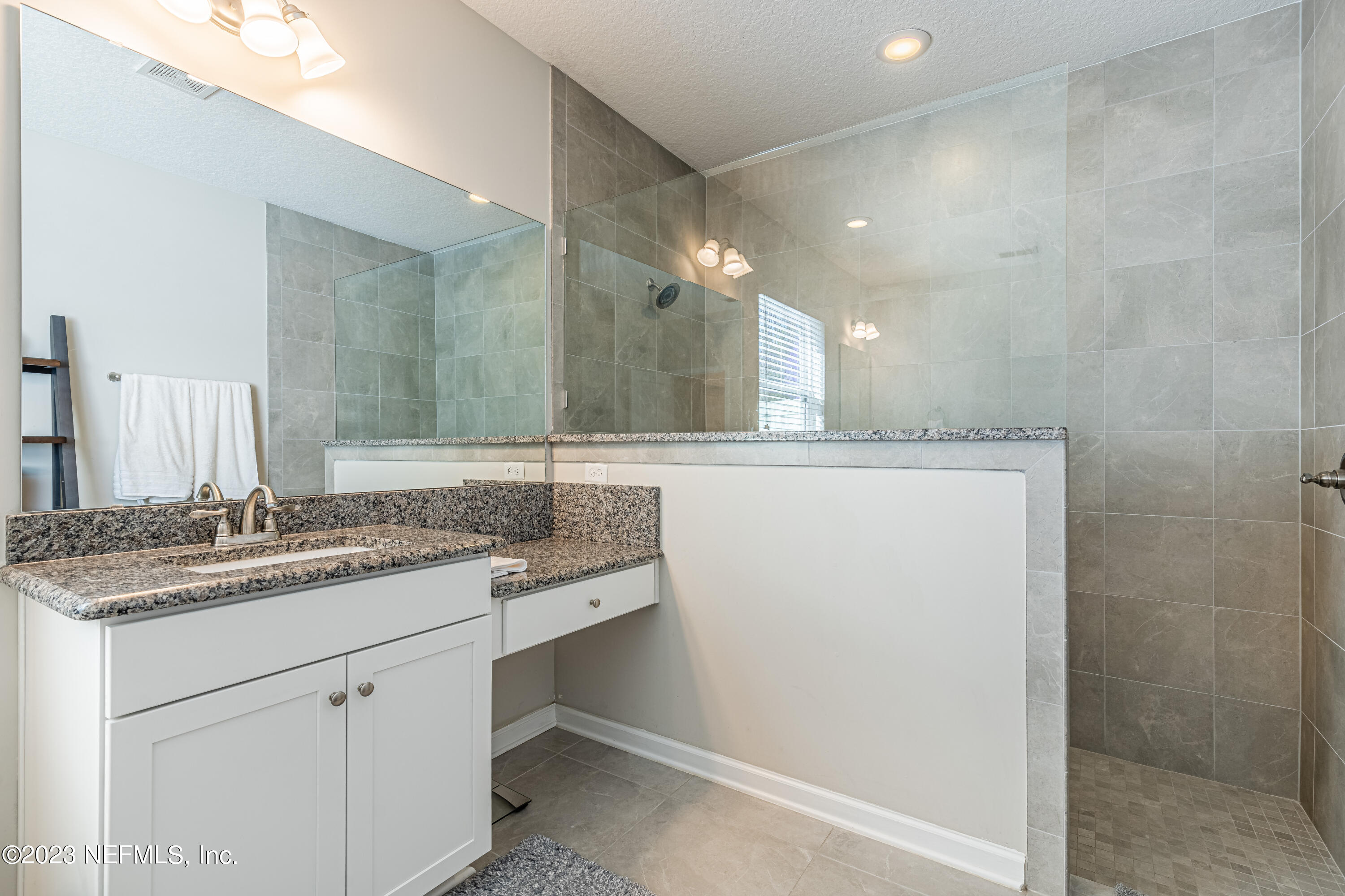 871 Bent Creek Drive St. Johns, FL 32259 - Photo 33 of 71 a bathroom with a granite countertop sink a mirror and a shower