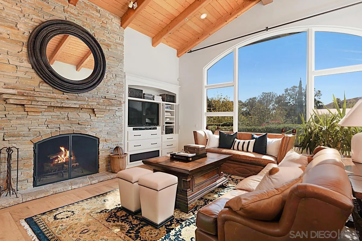 13657 Paseo De La Huerta Poway, CA 92064 - Photo 12 of 38 a living room with furniture a fireplace and a floor to ceiling window