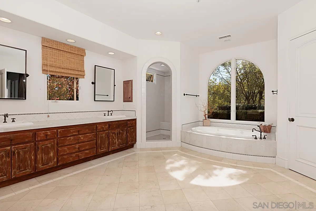 13657 Paseo De La Huerta Poway, CA 92064 - Photo 17 of 38 a spacious bathroom with a tub sink and mirror