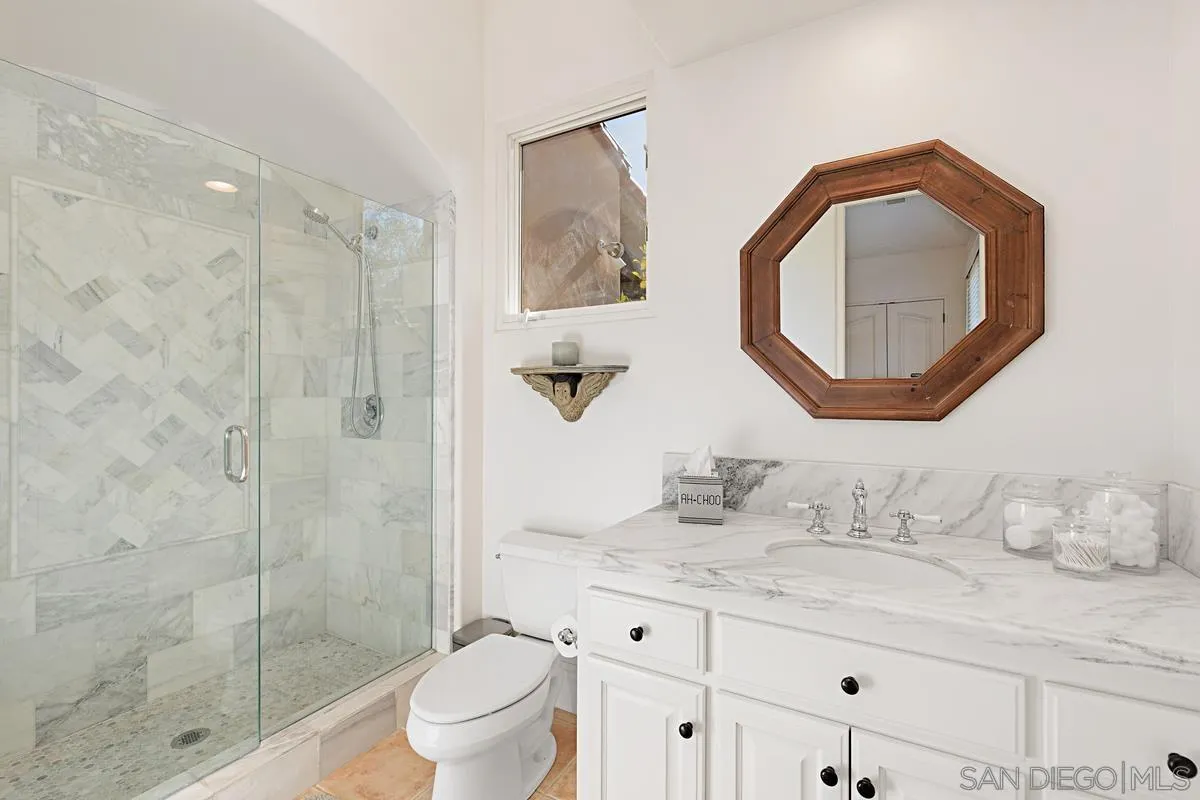 13657 Paseo De La Huerta Poway, CA 92064 - Photo 25 of 38 a bathroom with a granite countertop sink a toilet and a mirror