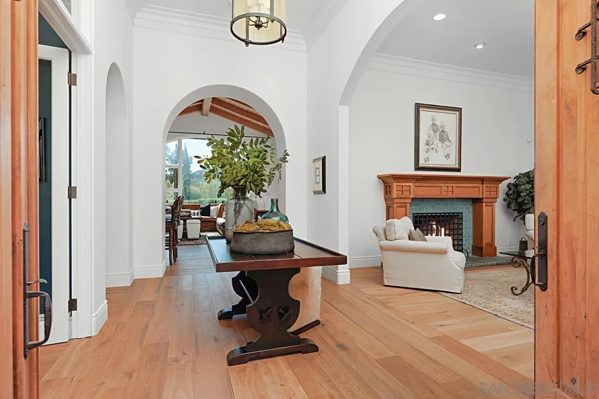 13657 Paseo De La Huerta Poway, CA 92064 - Photo 4 of 38 a living room with furniture a fireplace and potted plants