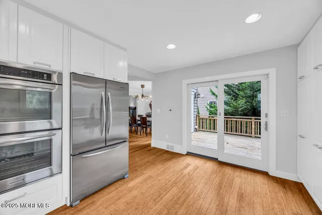 a kitchen with stainless steel appliances a refrigerator and wooden floor