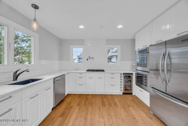 a kitchen with white cabinets and stainless steel appliances