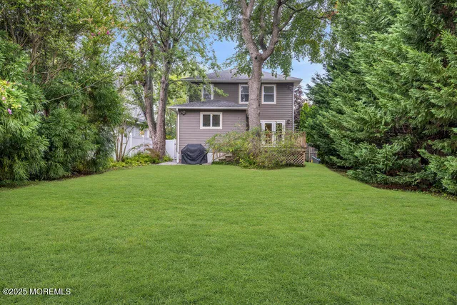 a view of a house with backyard and a tree