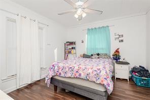 1713 Sycamore Street Commerce, TX 75428 - Photo 17 of 22 a bedroom with a bed and a chandelier