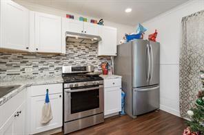 1713 Sycamore Street Commerce, TX 75428 - Photo 5 of 22 a kitchen with stainless steel appliances granite countertop a refrigerator stove and sink