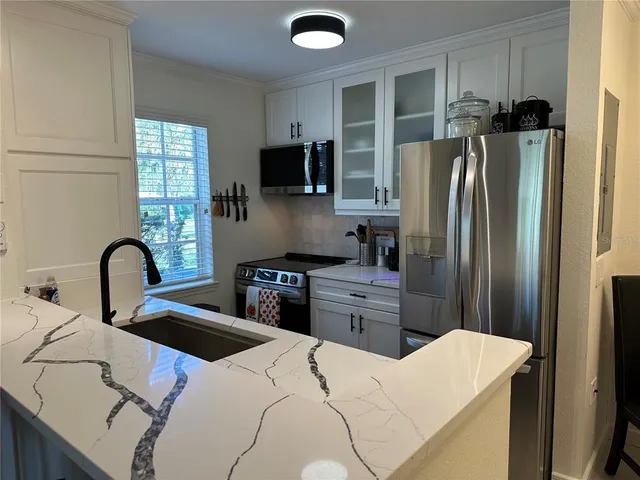 a kitchen with stainless steel appliances a refrigerator sink and microwave