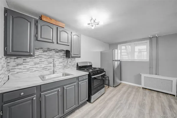 a kitchen with stainless steel appliances granite countertop a sink dishwasher a refrigerator and cabinets with wooden floor