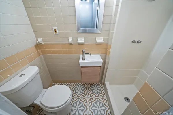 a white toilet sitting next to a white sink and vanity