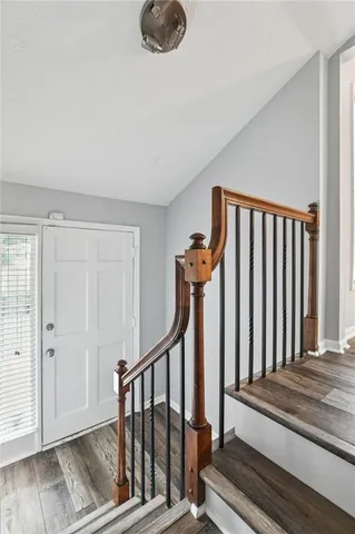 a view of a livingroom with wooden floor and staircase