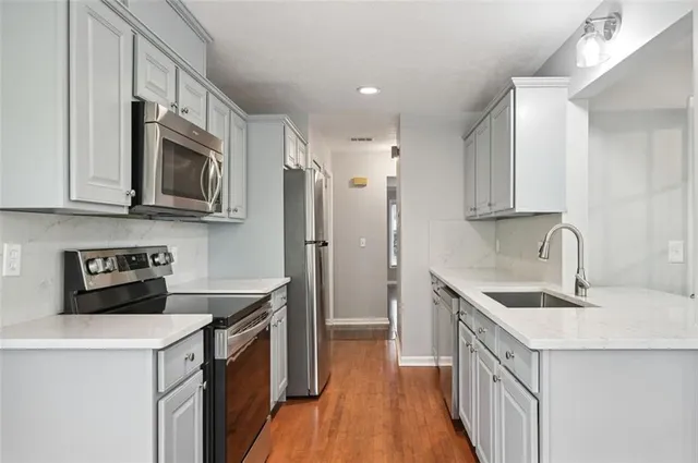 a kitchen with a sink a stove a microwave and a refrigerator