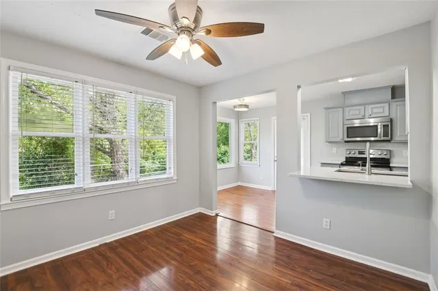 a view of a kitchen with wooden floor and a ceiling fan