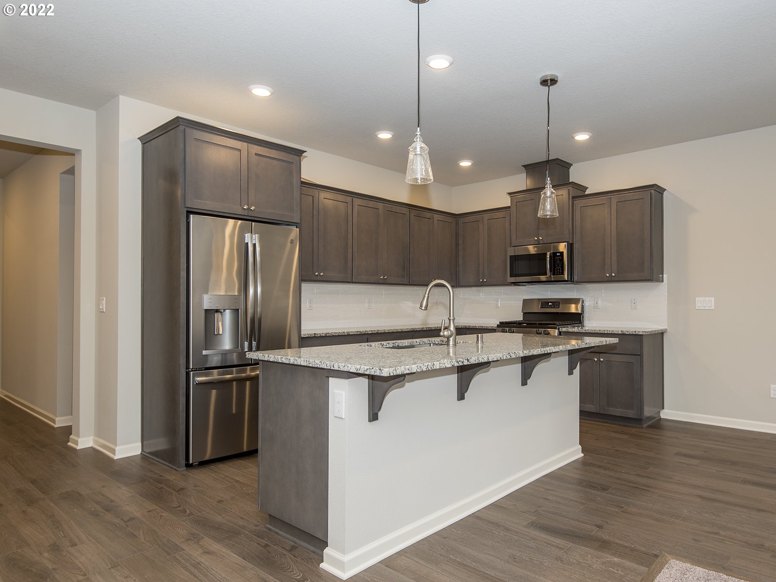 37372 Pink Street, Unit HS 71 Sandy, OR 97055 - Photo 3 of 7 a kitchen with kitchen island a sink stainless steel appliances and wooden floor