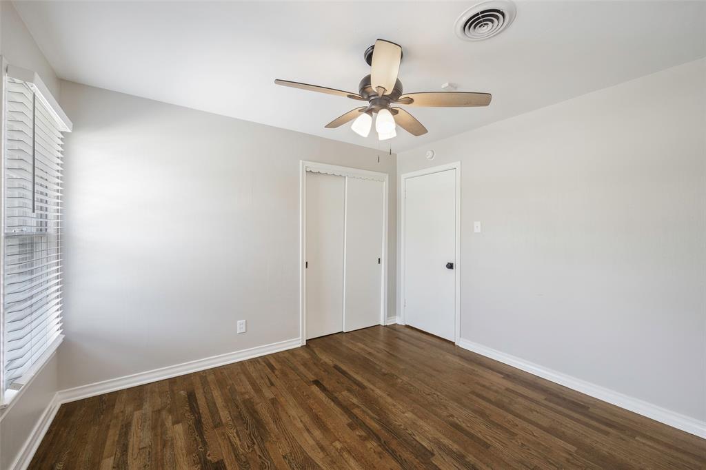 2323 Sutter Street Dallas, TX 75216 - Photo 26 of 30 Unfurnished bedroom with multiple windows, dark wood-type flooring, a closet, and ceiling fan