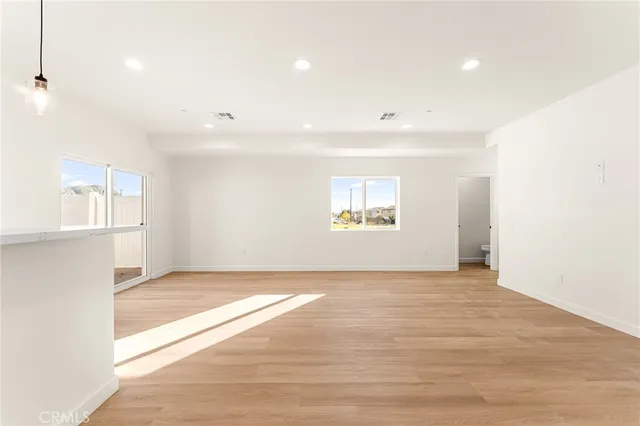 an empty room with windows and mirror