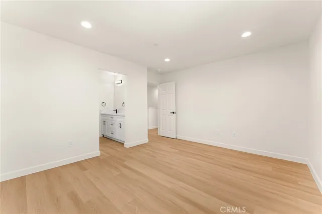 a spacious bathroom with a double vanity sink a toilet and a mirror