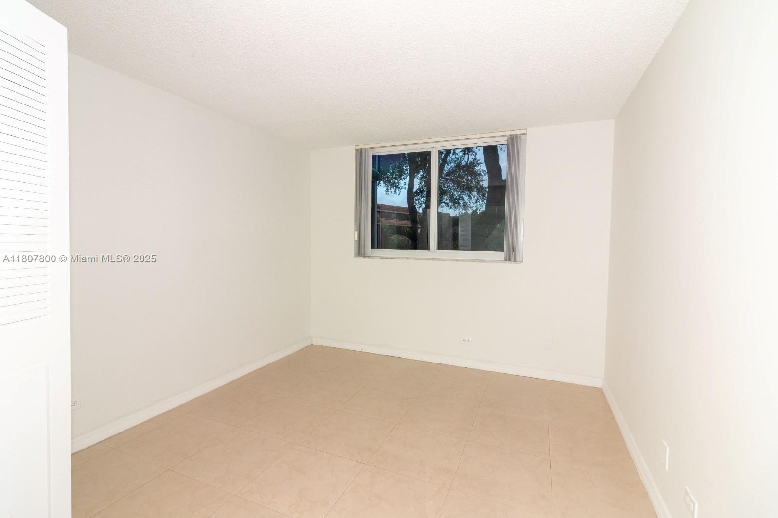 447 Northeast 195th Street, Unit 217 Miami, FL 33179 - Photo 12 of 22 a view of an empty room with a window