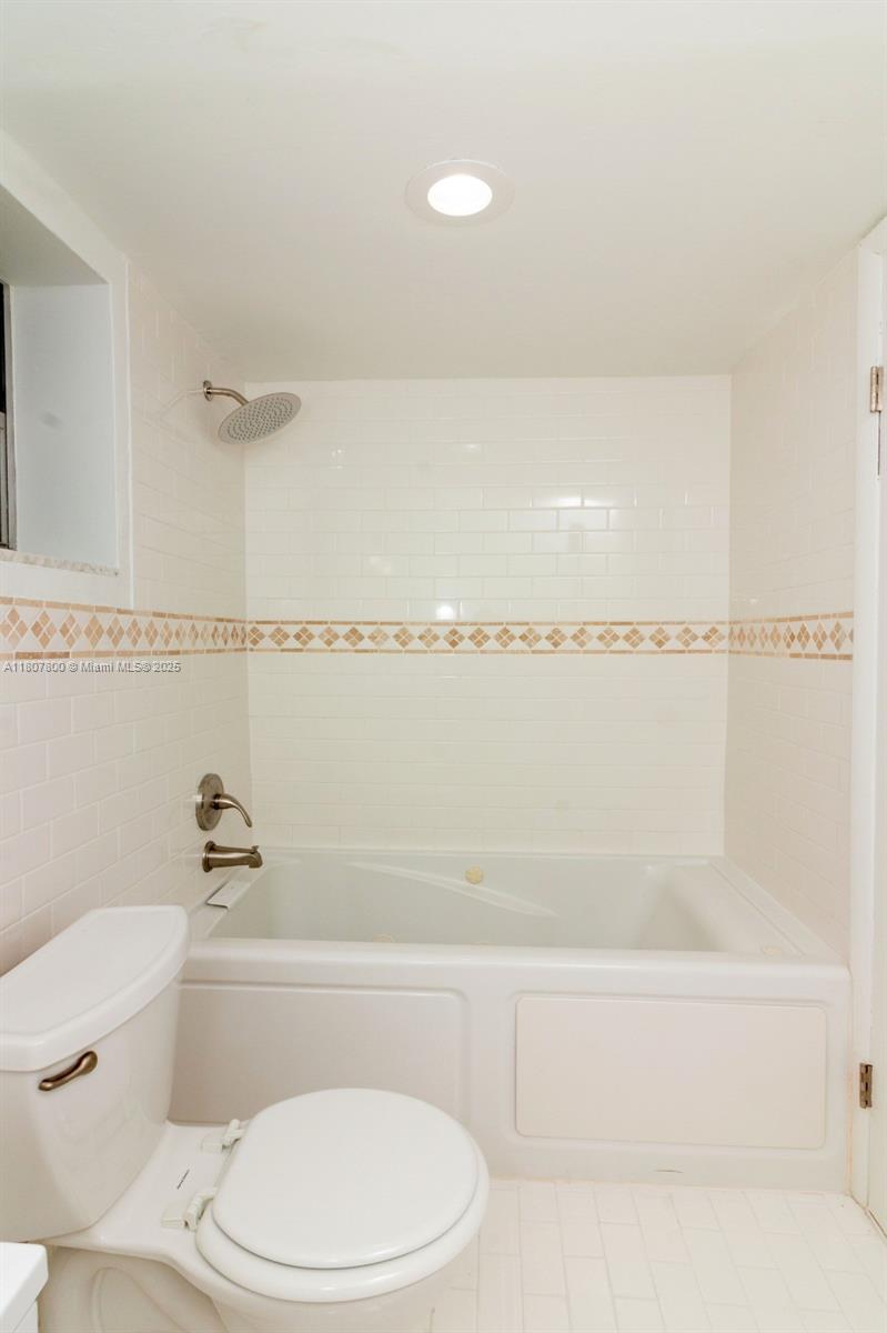 447 Northeast 195th Street, Unit 217 Miami, FL 33179 - Photo 17 of 22 a bathroom with a toilet and a bathtub