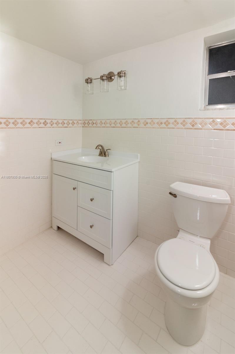 447 Northeast 195th Street, Unit 217 Miami, FL 33179 - Photo 18 of 22 a bathroom with a toilet a sink and vanity