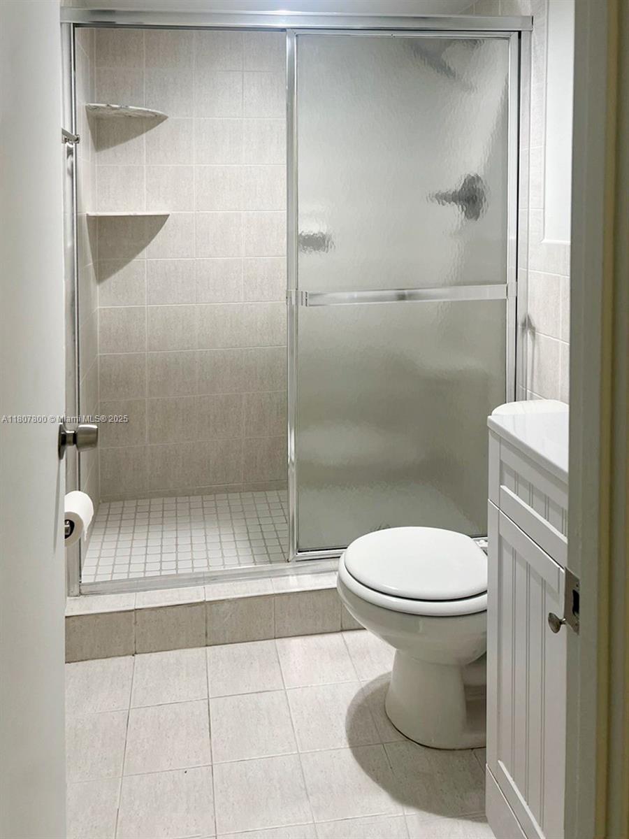 447 Northeast 195th Street, Unit 217 Miami, FL 33179 - Photo 6 of 22 a bathroom with a toilet and a shower