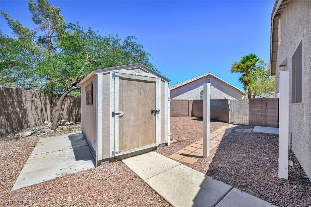 1234 Sunfire Street Henderson, NV 89014 - Photo 36 of 40 A compact storage shed stands ready for tools and outdoor gear in this well-maintained backyard space.