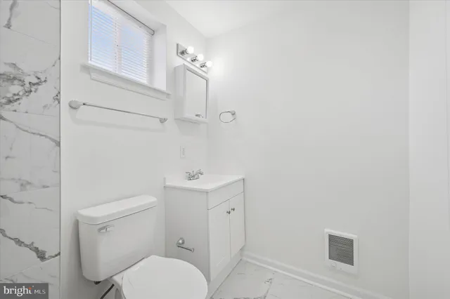 a white toilet sitting next to a bathroom sink