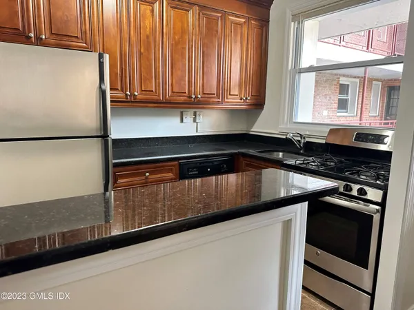 a kitchen with granite countertop white cabinets and black appliances